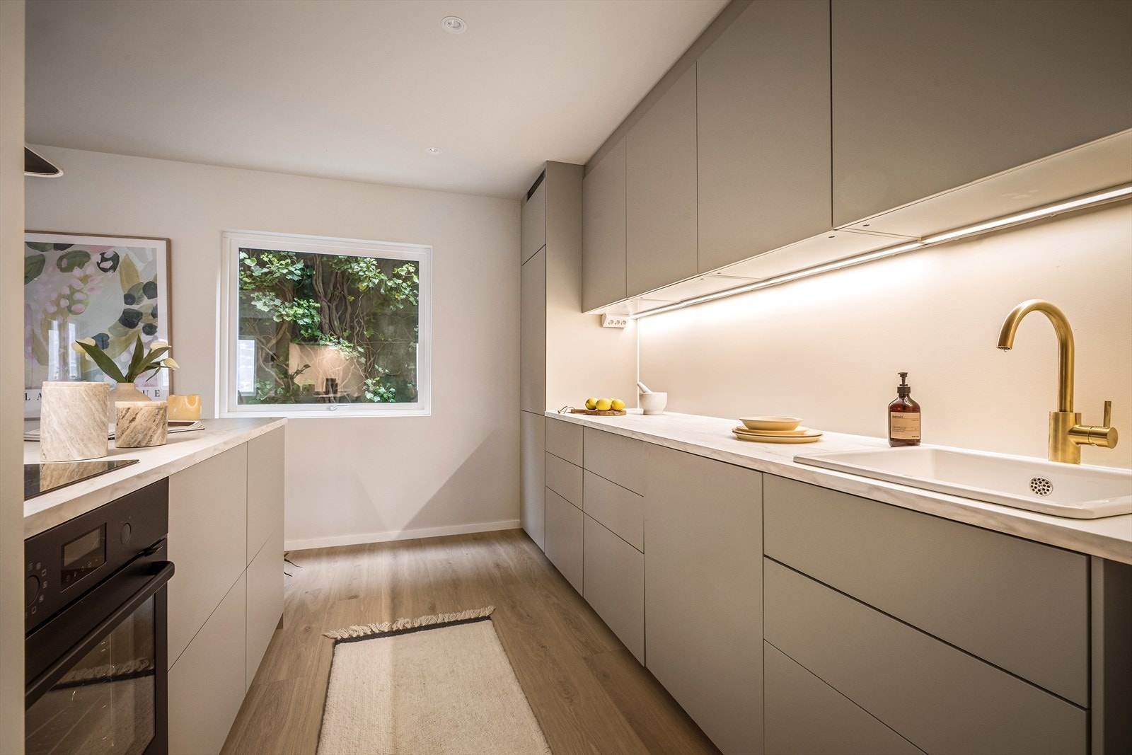 Kjøkkenet har slette fronter og laminat benkeplate, og inneholder integrerte hvitevarer som platetopp, stekeovn, oppvaskmaskin og kombiskap. Galleribilde