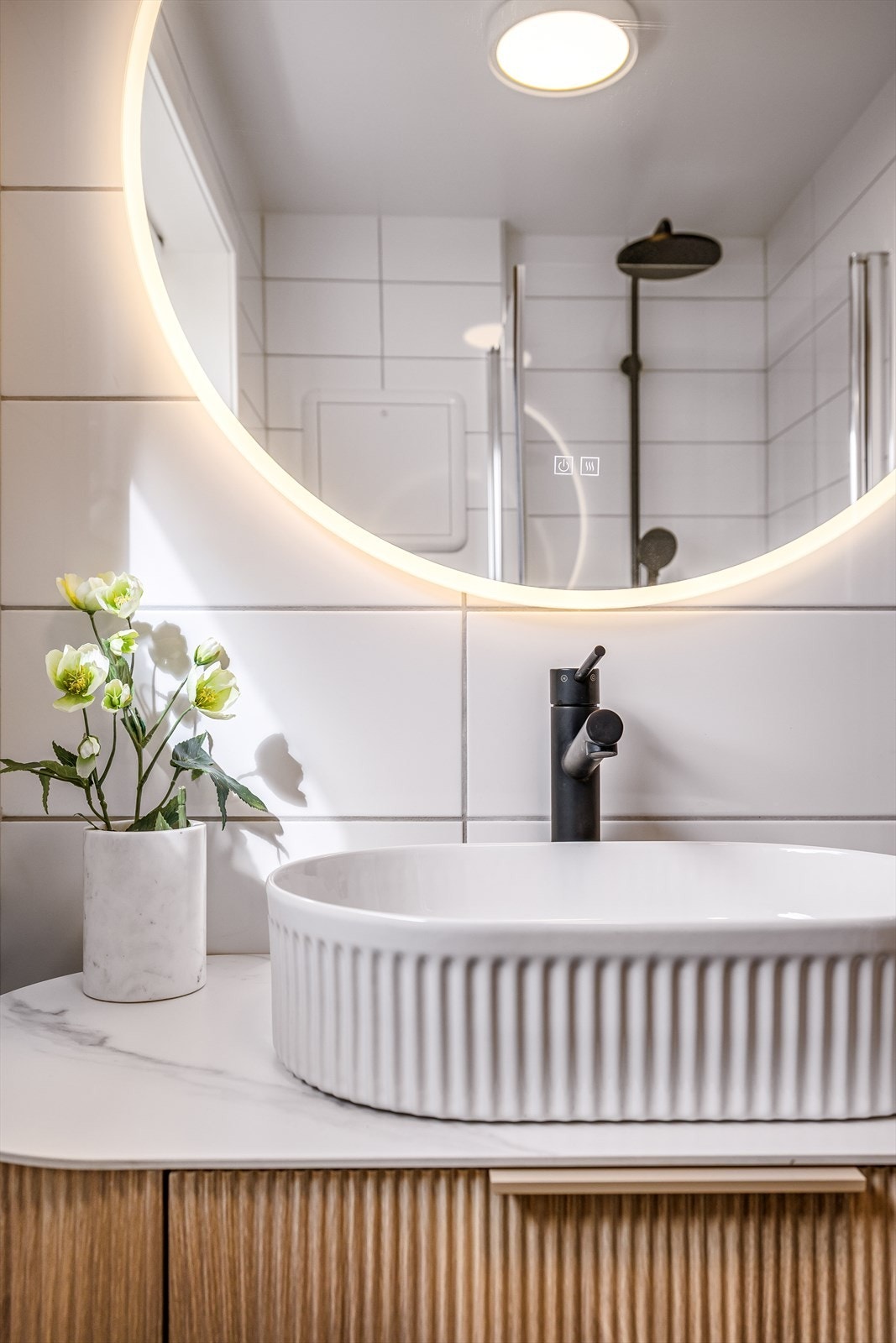 Badet er innredet med servantm vegghengt toalett og dusjhjørne. Galleribilde