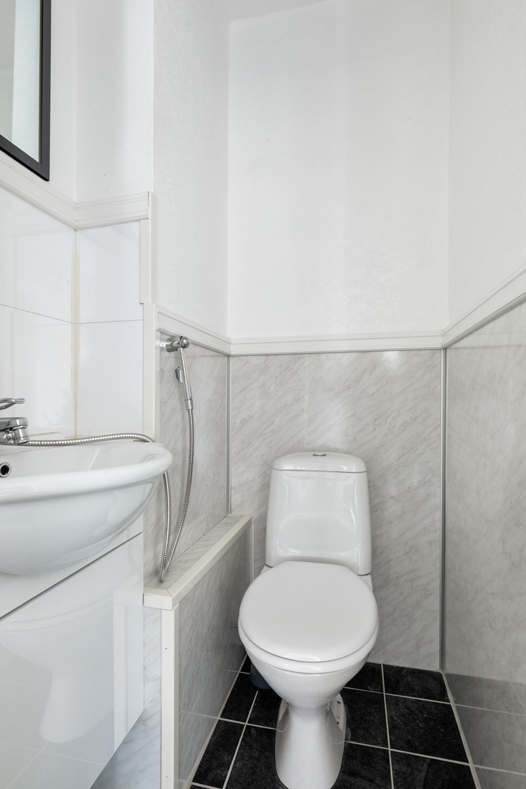 Toalettrommet har overflater bestående av flis på gulv, baderomsplater og malt tapet på vegger. Baderommet har lys innredning med heldekkende servant og er utstyrt med toalett. Galleribilde