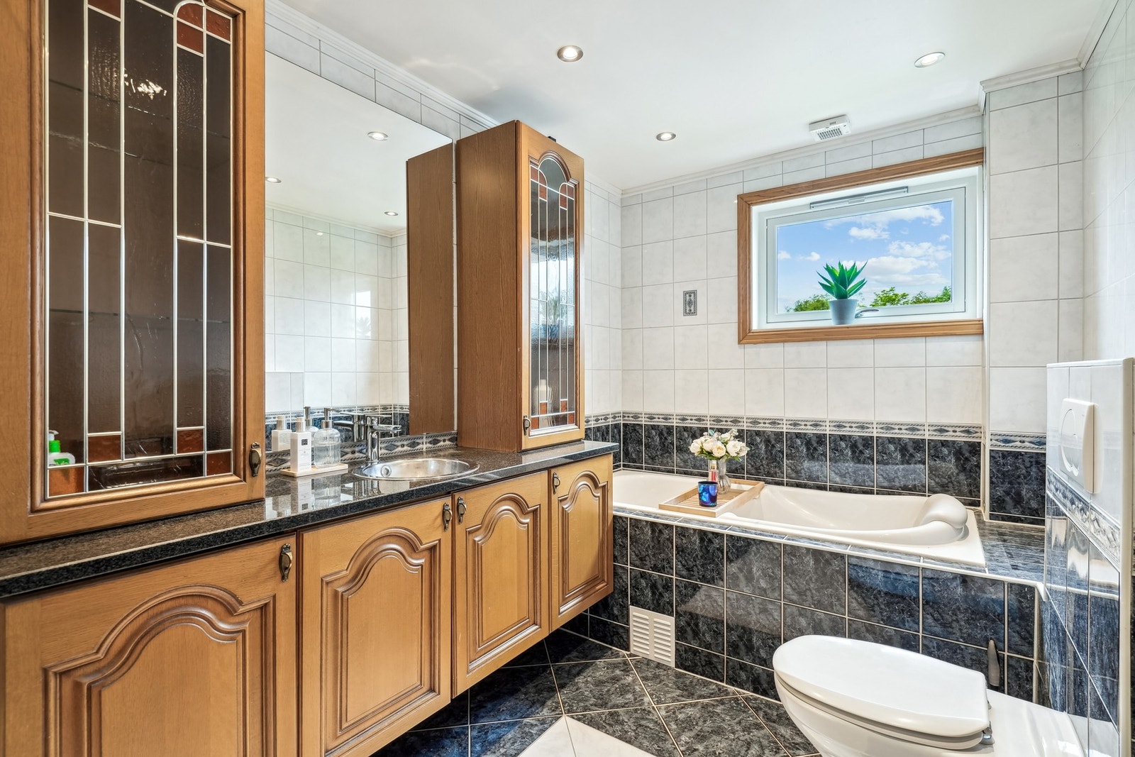 Baderommet i andre etasje er innredet med badekar og en romslig baderomsinnredning med klassiske, profilerte fronter. Galleribilde