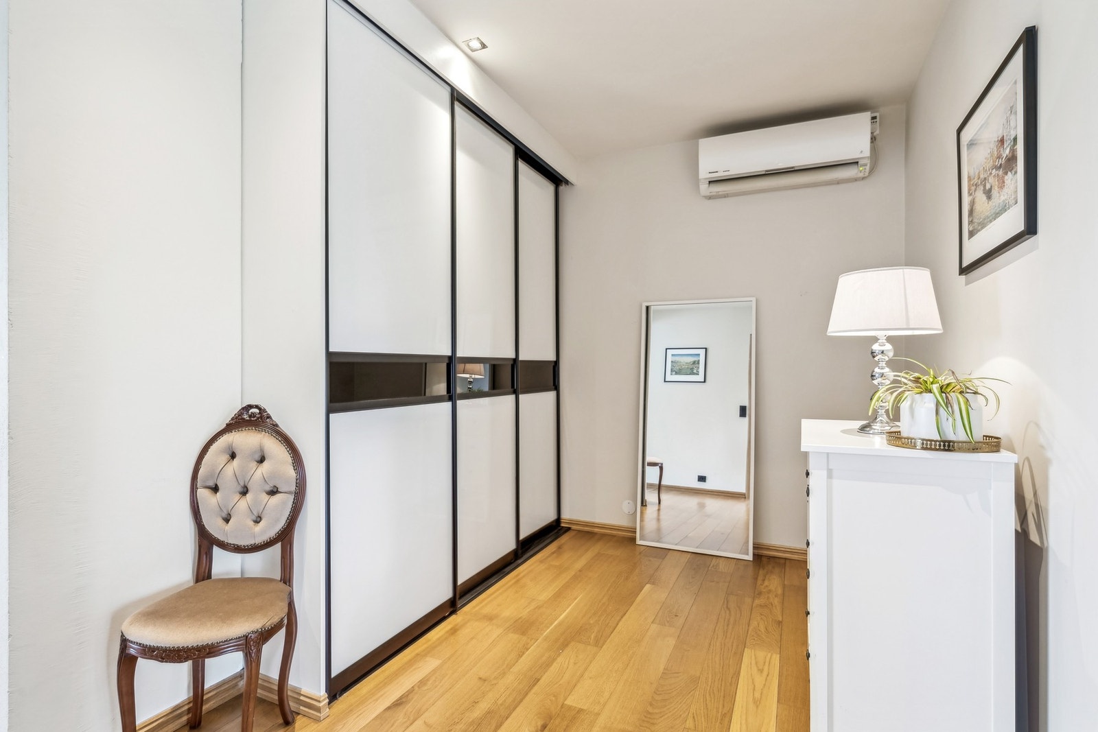 Gang mellom de to stuene, med praktisk skyvedørsgarderobe. Boligen varmes opp med varmepumpe. Galleribilde