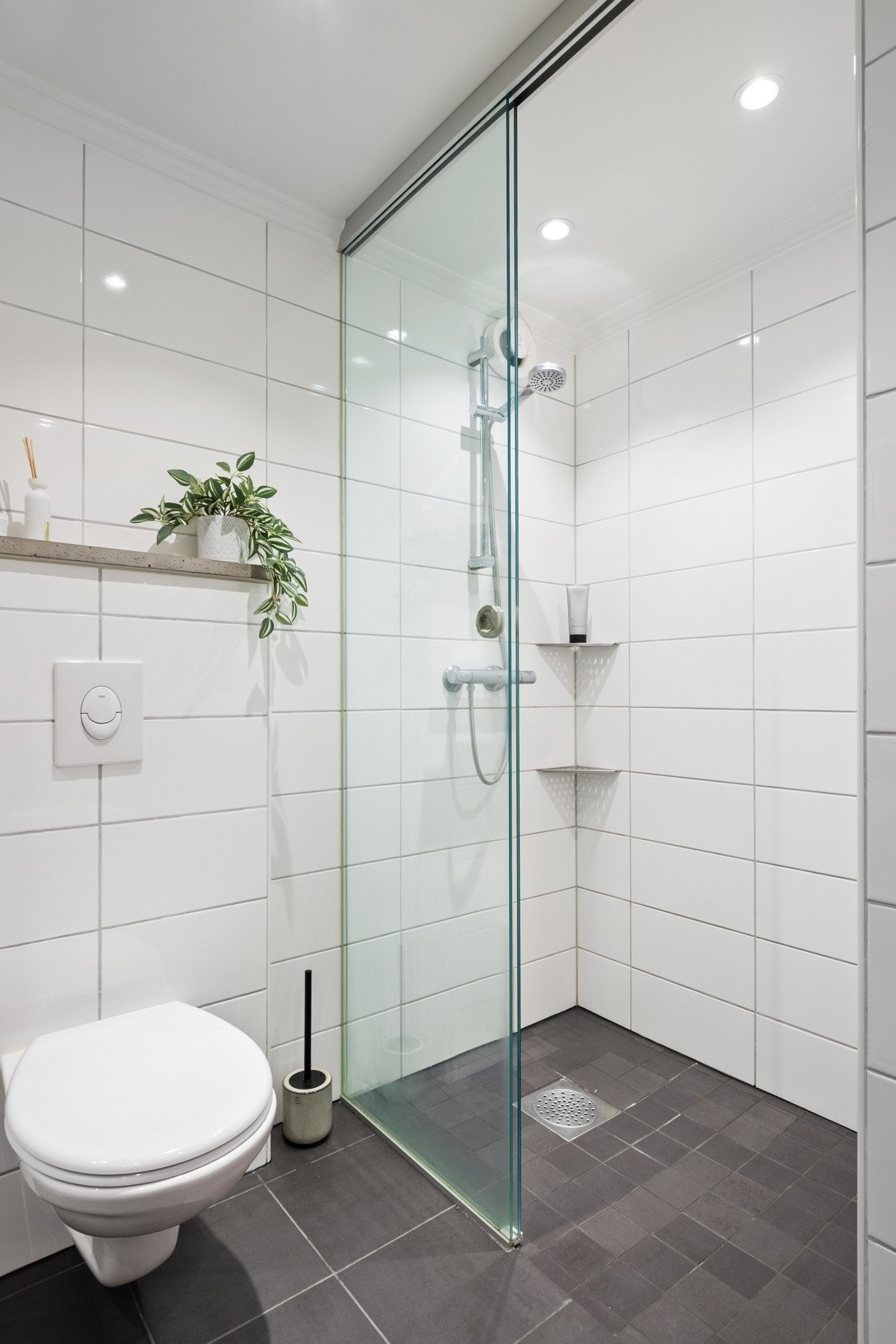 Videre har badet veggmontert toalett, dusjnisje med skyvedør og mekanisk avtrekk. Galleribilde