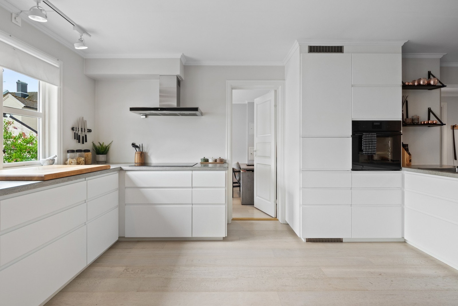 Innredningen har benkeplate i betong med nedfelt kum i benkeplaten og hvite, glatte fronter uten håndtak. Galleribilde