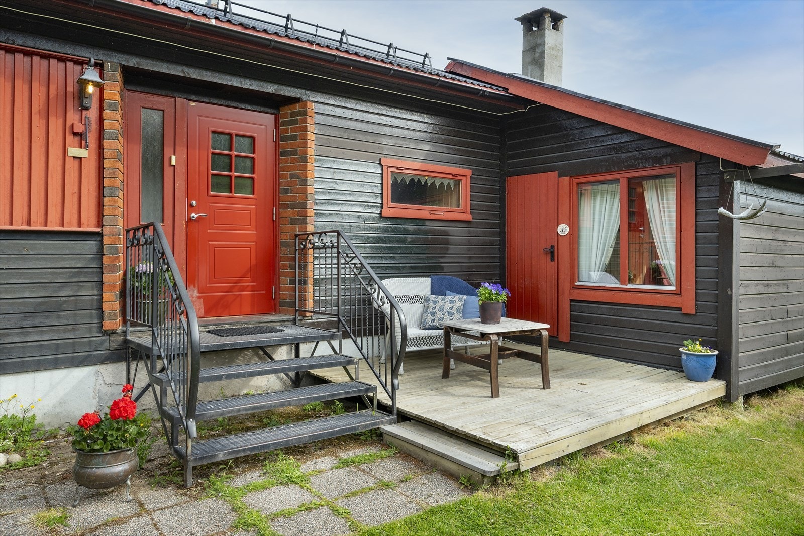 En enkel ståltrapp med noen få trinn tar deg videre inn. Rett ved inngangen er det anlagt en liten uteplass. Galleribilde