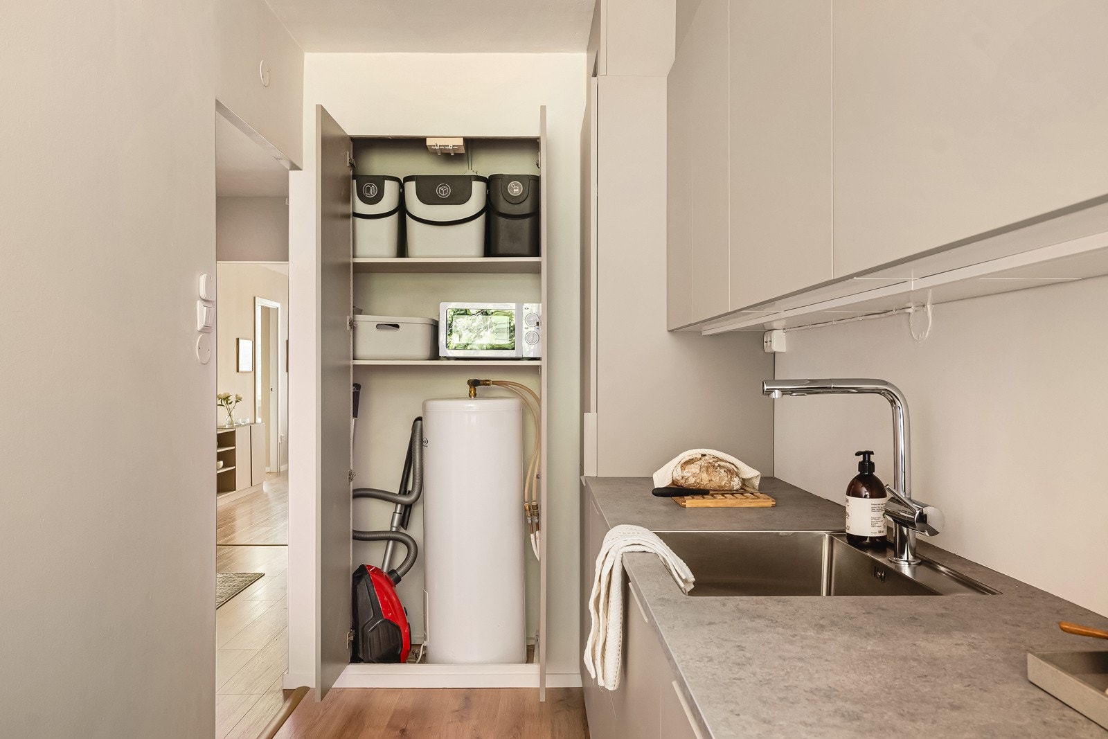 I enden av kjøkkenet er en kjempepraktisk skap-bod med plass til mikro, støvsuger, panteflasker osv. Galleribilde