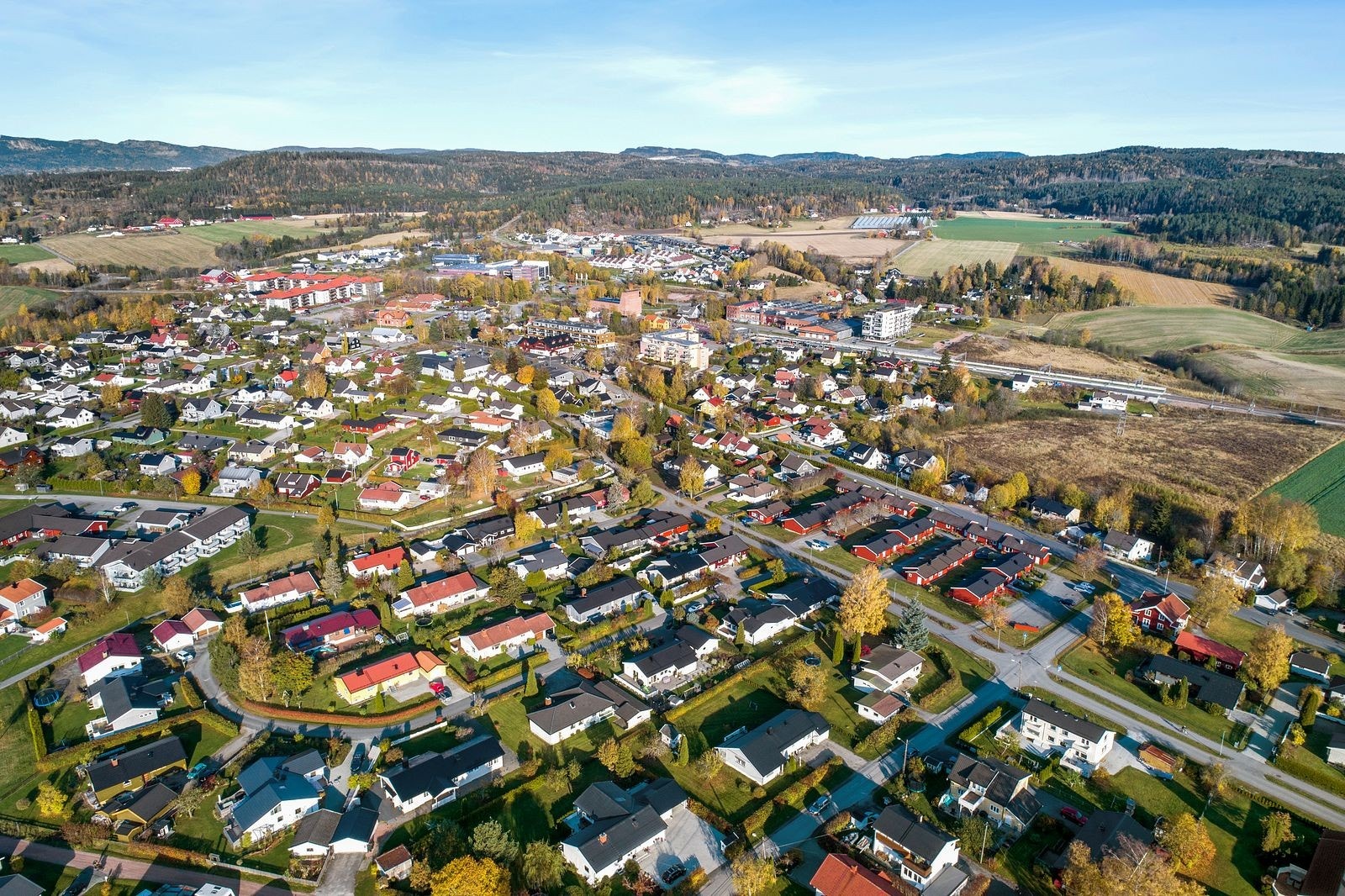 Dronebilde over Spikkestad med togstasjon, Rema 1000, Kiwi, legesenter og apotek m.m. Galleribilde