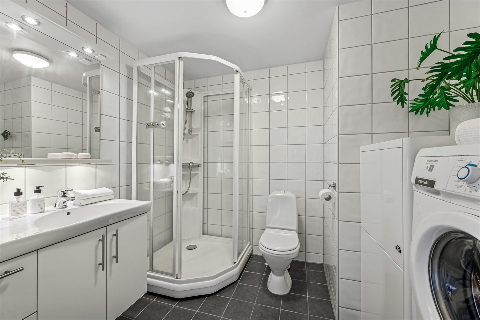 Delikat flislagt baderom fra 2011. Rommet er av god størrelse med servantskap og tilhørende vegghengt speil med belysning. Galleribilde