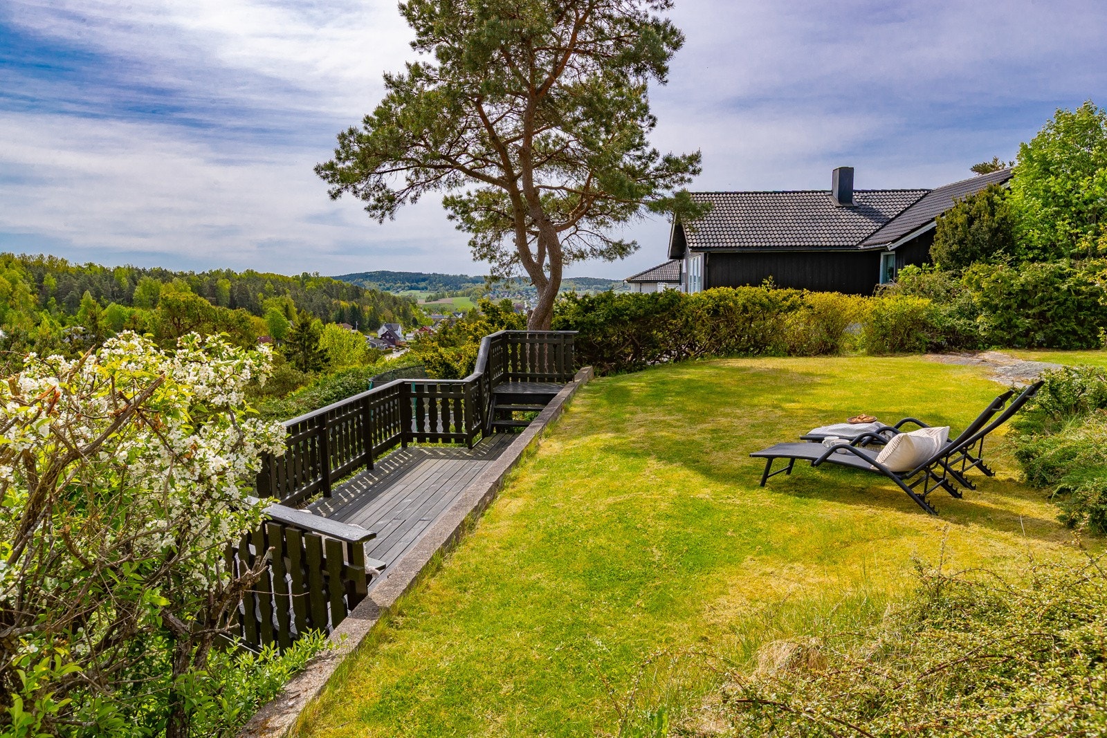 Uteplass med trapp ned mot skråning som tilhører eiendommen Galleribilde