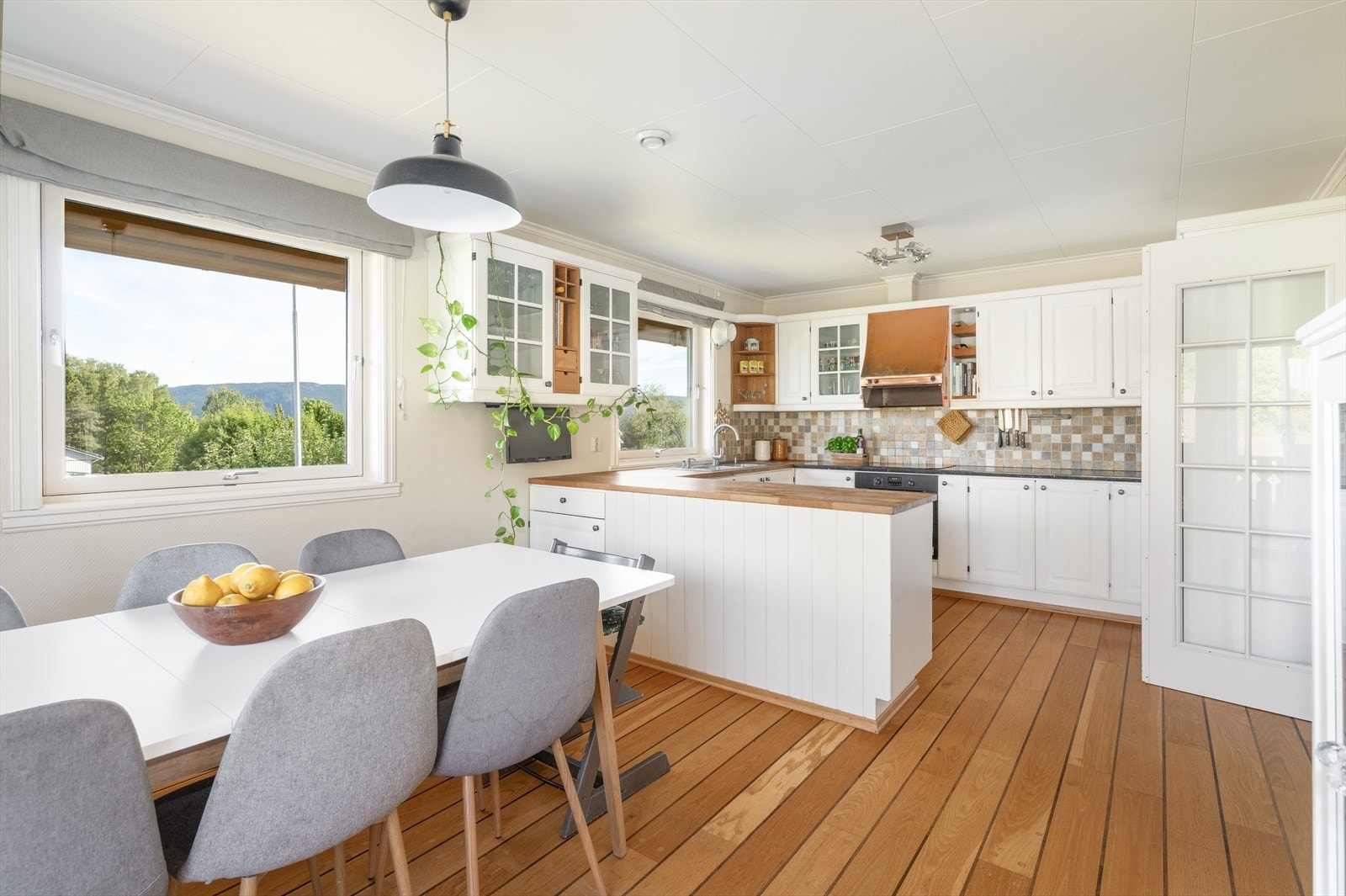 Lyst og delikat kjøkken med meget god skap- og benkeplass, samt romslig spiseplass og utgang til terrasse. Galleribilde