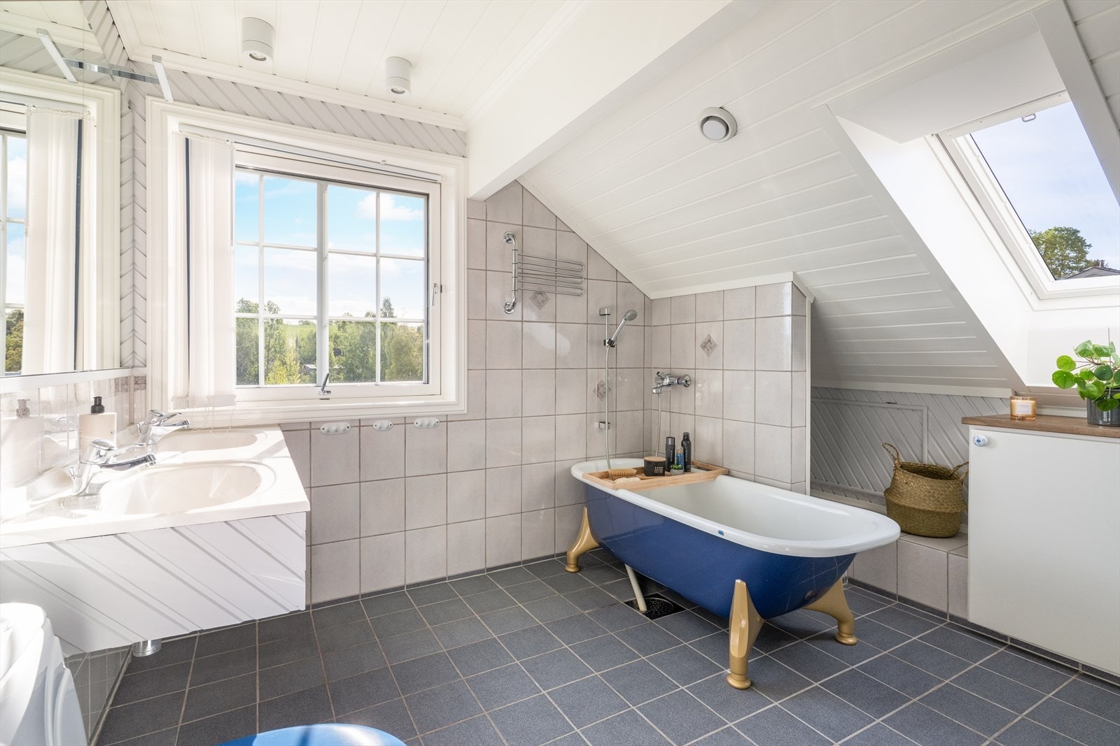 Bad fra ca. 1990 med flislagt gulv og varmekabler, flis på vegg i våtsone og paneler på resterende vegger. Galleribilde