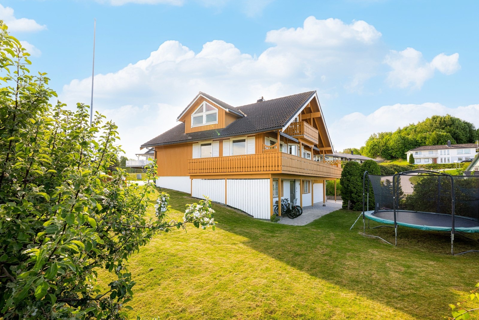 Romslige, steinbelagte gårdsplasser på begge sider av boligen, med gode parkeringsmuligheter samt tilliggende garasje. Galleribilde