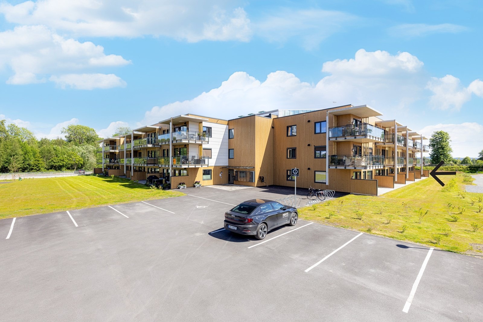 Fasade med hovedinngang og gjesteparkeringsplasser Galleribilde