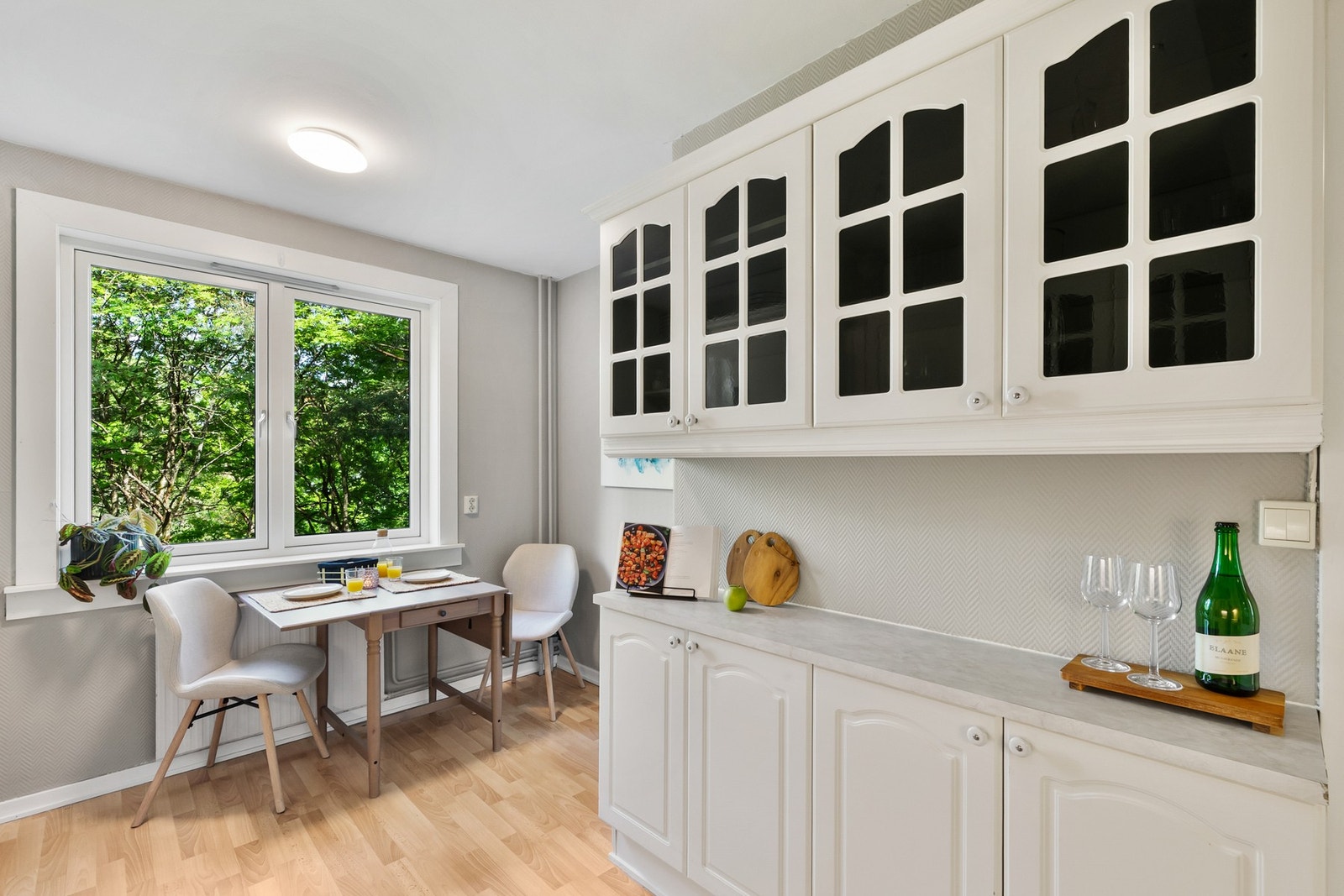 Kjøkkenets hvite, glatte fronter og den robuste laminatbenkeplaten med integrert vask skaper en stilren helhet og et elegant, tidløst preg. Galleribilde