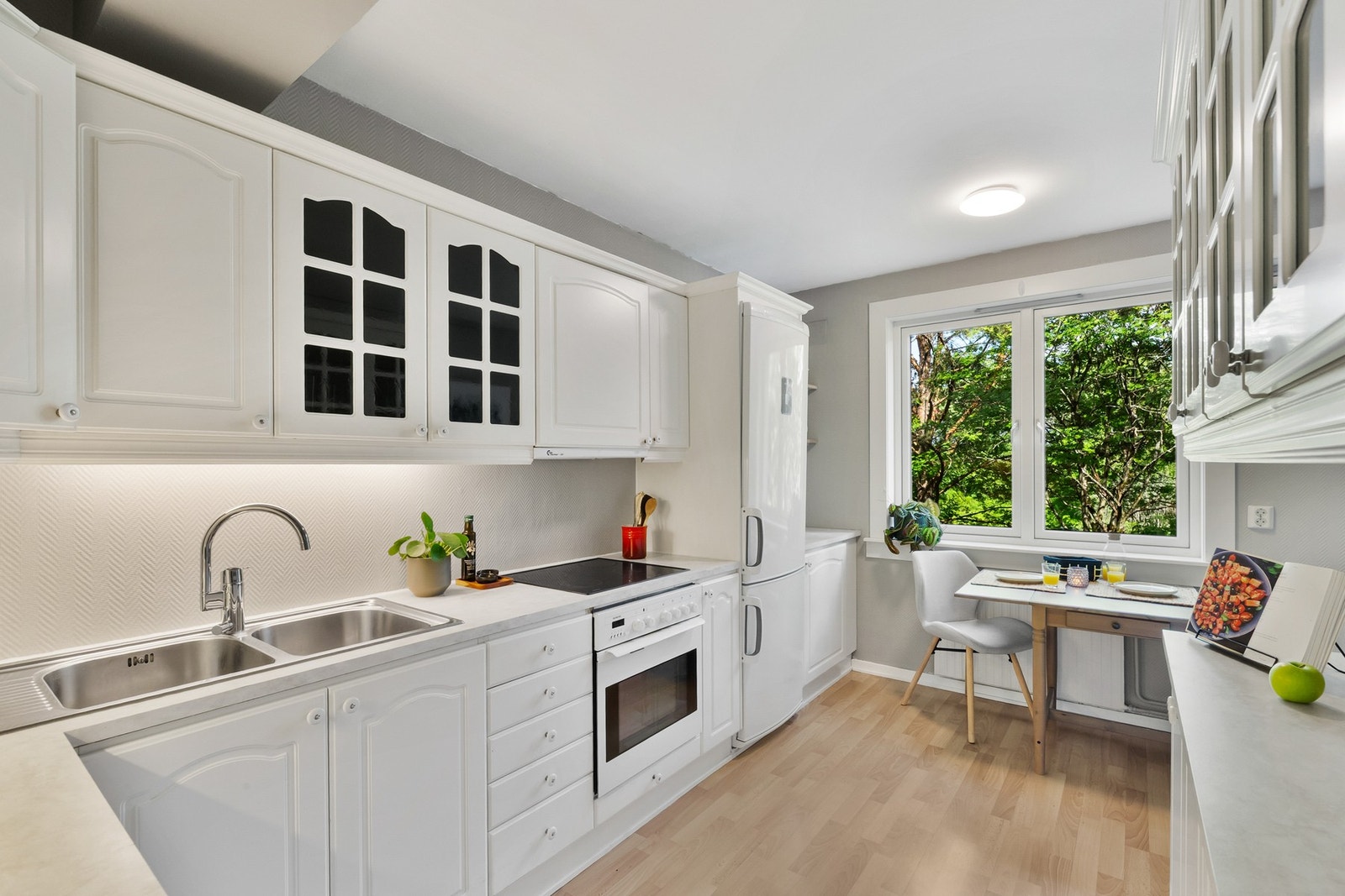 Med klassiske profilerte fronter og en praktisk laminat benkeplate kombinerer kjøkkenet stil og funksjonalitet. Hvitevarene er delvis integrert og inkluderer kjøl-/fryseskap, oppvaskmaskin, platetopp og stekeovn - alt du trenger for en effektiv kjøkkenhve Galleribilde