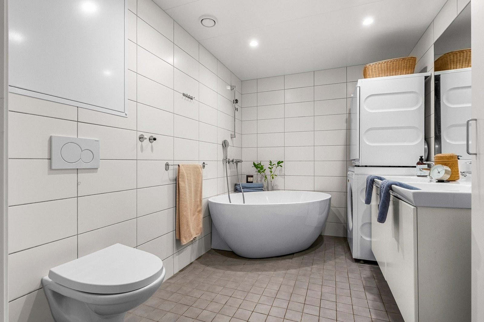 Badet er utstyrt med vegghengt toalett, badekar og kran og avløp fra vaskemaskin. Galleribilde