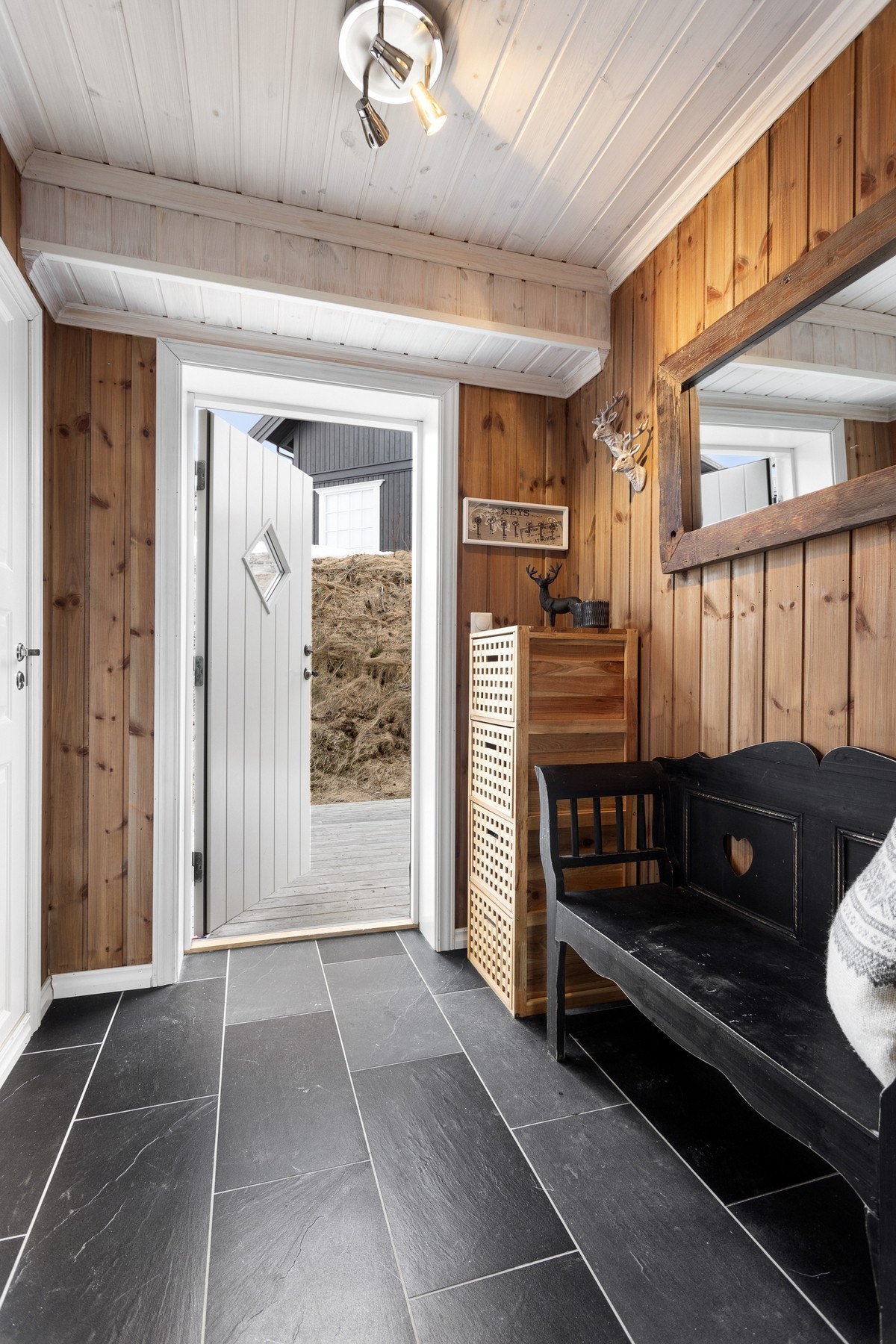 Lun og innbydende entré med fliser og varmekabler i gulvet. Fra entréen er det direkte adkomst inn til toalettrom Galleribilde