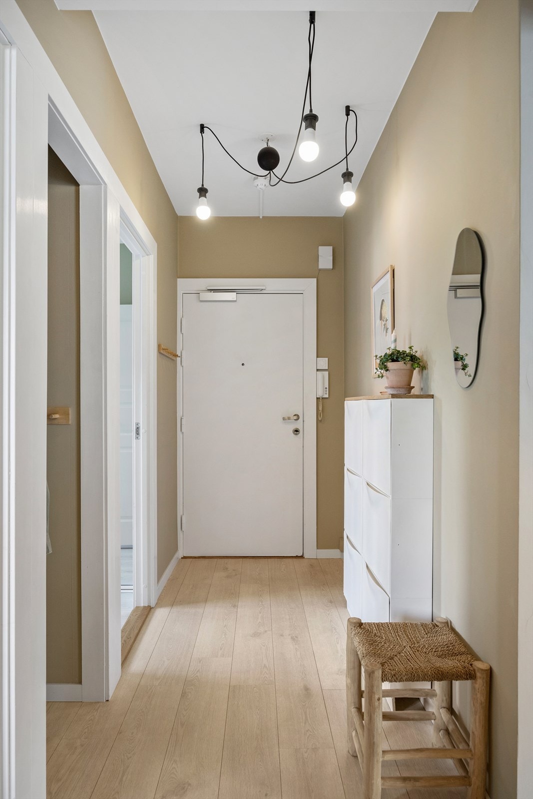 Velkommen inn! Leiligheten har en innbydende entré som skaper et umiddelbart godt førsteinntrykk. Her kan du enkelt henge i fra deg yttertøy. Galleribilde