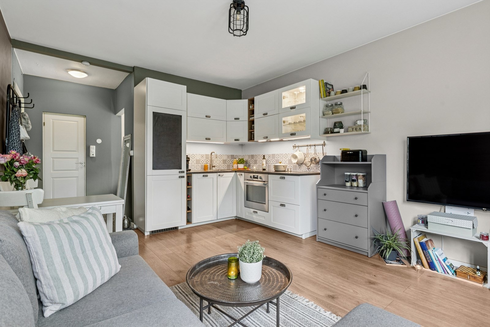 Åpen stue/kjøkkenløsning med plass til sofagruppe, spisegruppe, tv-møblement og oppbevaring Galleribilde