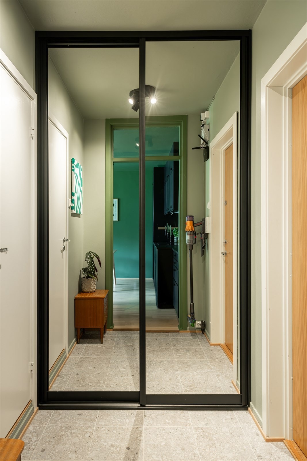 Romslig entré med god plass til oppbevaring av ytterklær og sko i tilhørende skyvedørsgarderobe Galleribilde