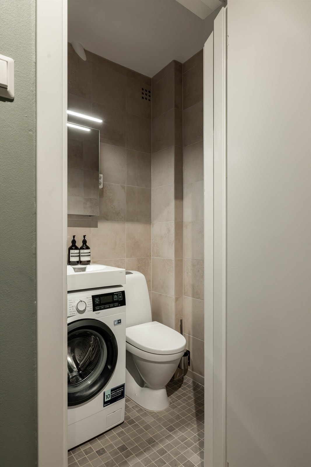 Baderomsinnredningen består av servant, dusjsone, toalett og opplegg for vaskemaskin Galleribilde