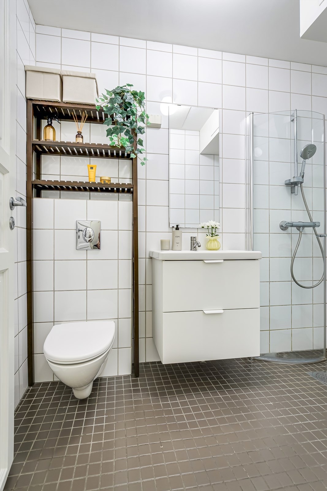 Innredningen består av servantskap med skuffeseksjon, speil og dusjhjørne med innfellbare glassdører Galleribilde