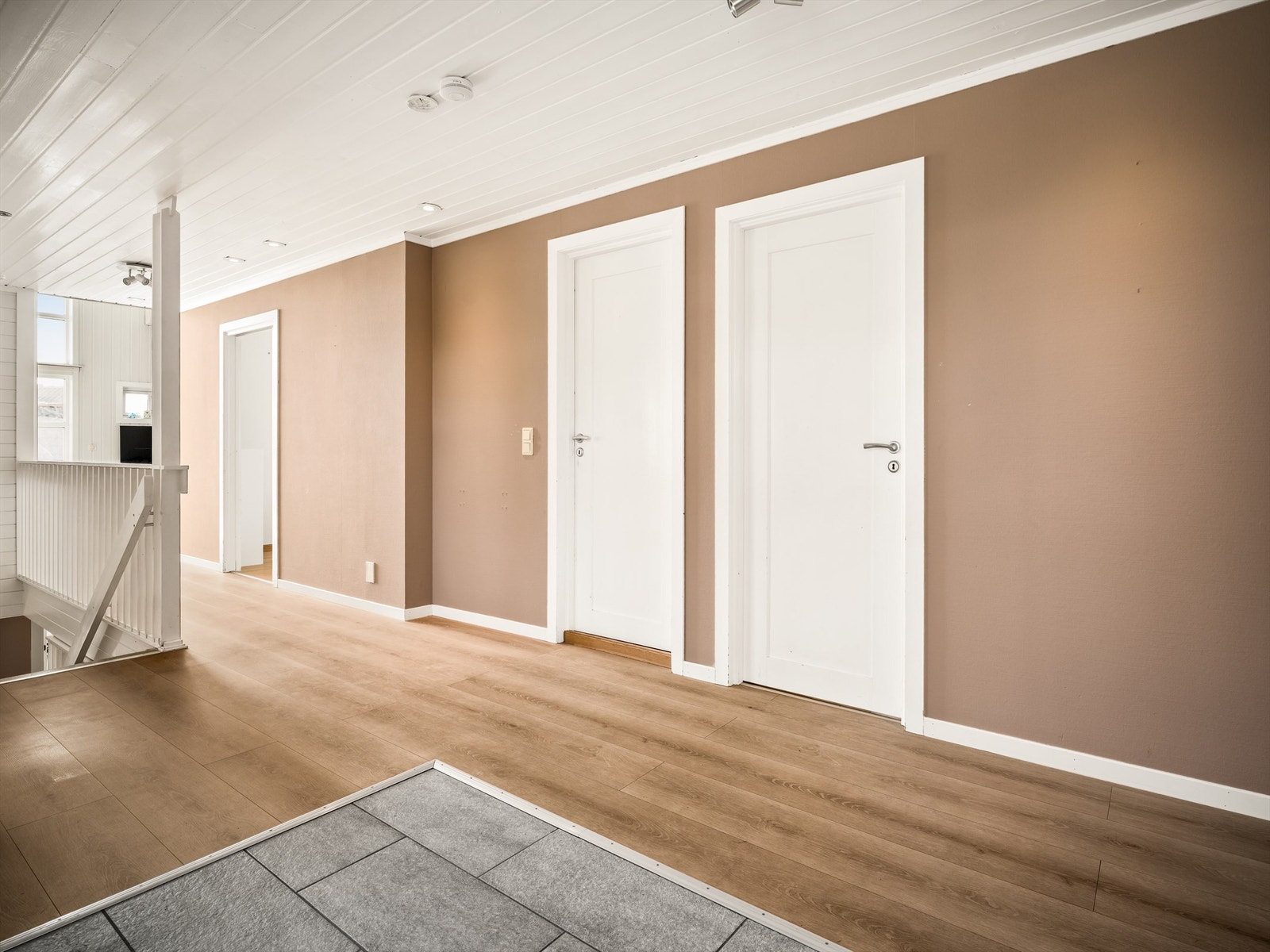 Soverommene er tilbaketrukne fra etasjens sosiale del og samlet omkring gangen. Spotter over gangen ble skiftet ut i 2021. Galleribilde