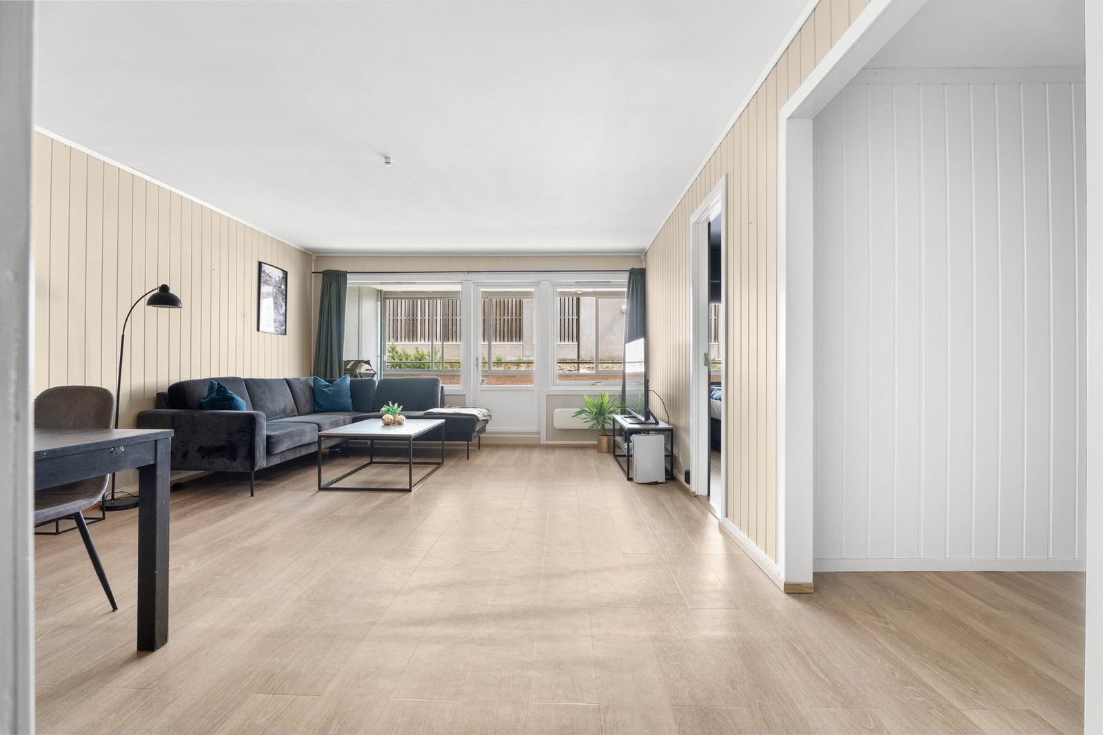 Stuen er malt i lyse og moderne farger med store vinduer som sikrer godt med naturlig lys inn til boligen Galleribilde