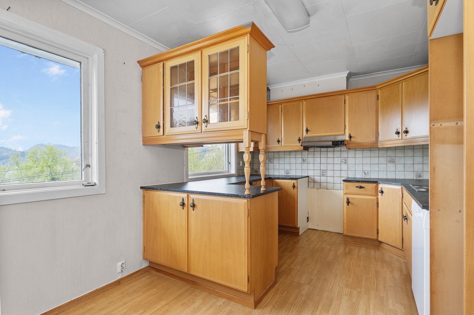 Kjøkken med slette fronter og laminat benkeplate Galleribilde