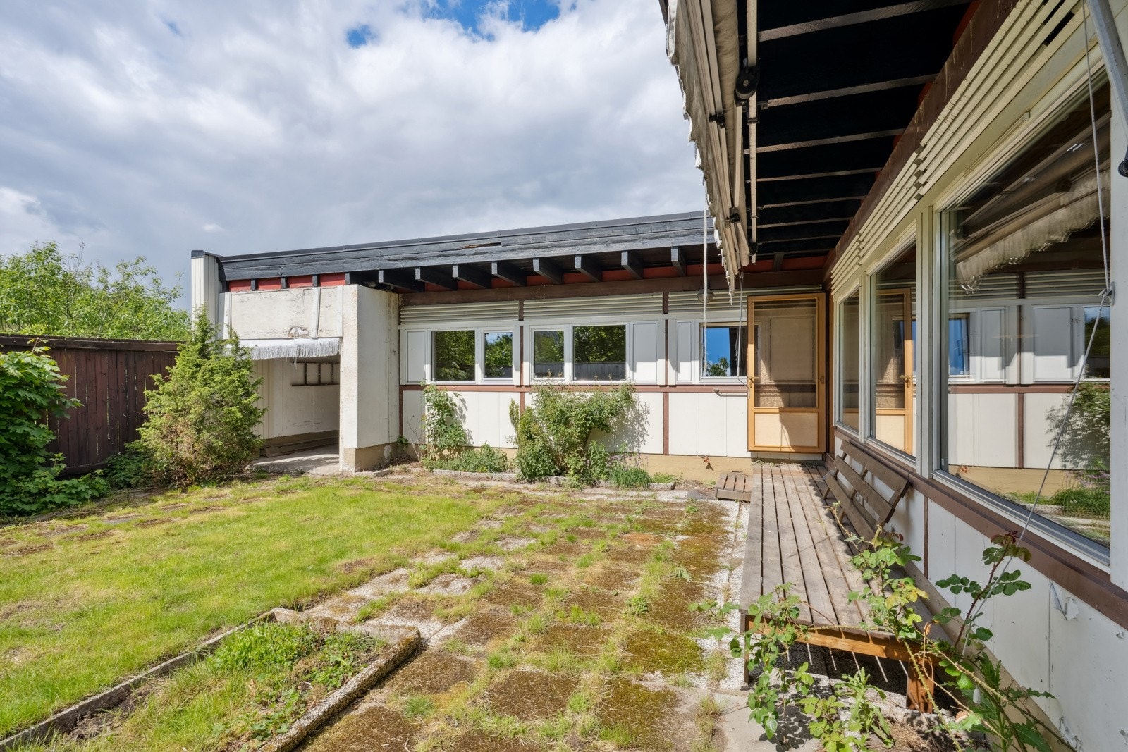 Hellelagt solplass inn mot stuesiden. Solrikt, markise i hele lengden (bør kanskje bytte duk). Galleribilde