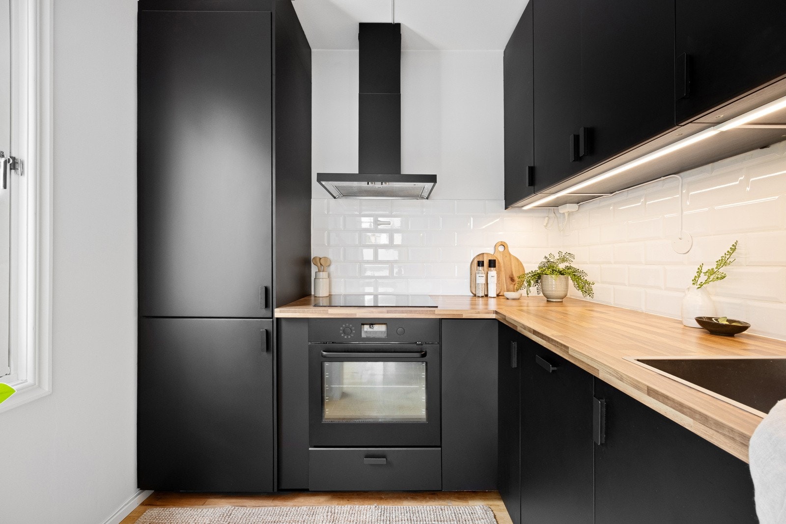 Integrerte hvitevarer bestående av komfyr, induskjonstopp, oppvaskmaskin og kjøleskap med frysedel som medfølger handelen. Galleribilde