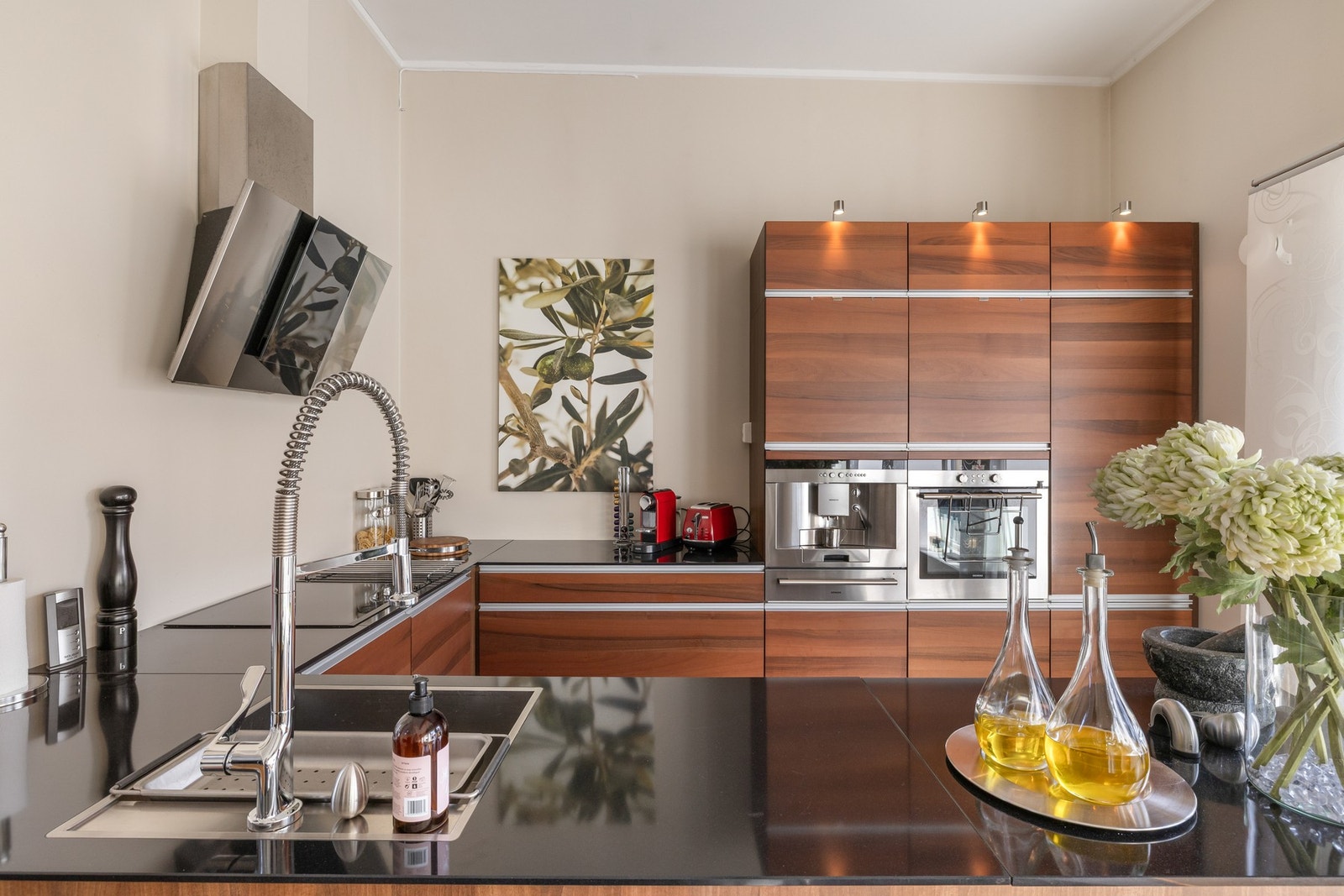 Videre er kjøkkenet utstyrt med integrerte hvitevarer som vinskap, kaffemaskin, kjøl-/fryseskap, oppvaskmaskin, tallerkenvarmer, stekeovn og koketopp, samt ventilator, benkestikk og god arbeidsbelysning Galleribilde