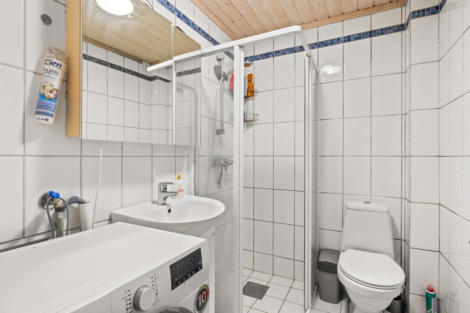 Bad fra 2004 med dusj og opplegg for vaskemaskin i tilknytting til peisestuen i boligens underetasje. Galleribilde