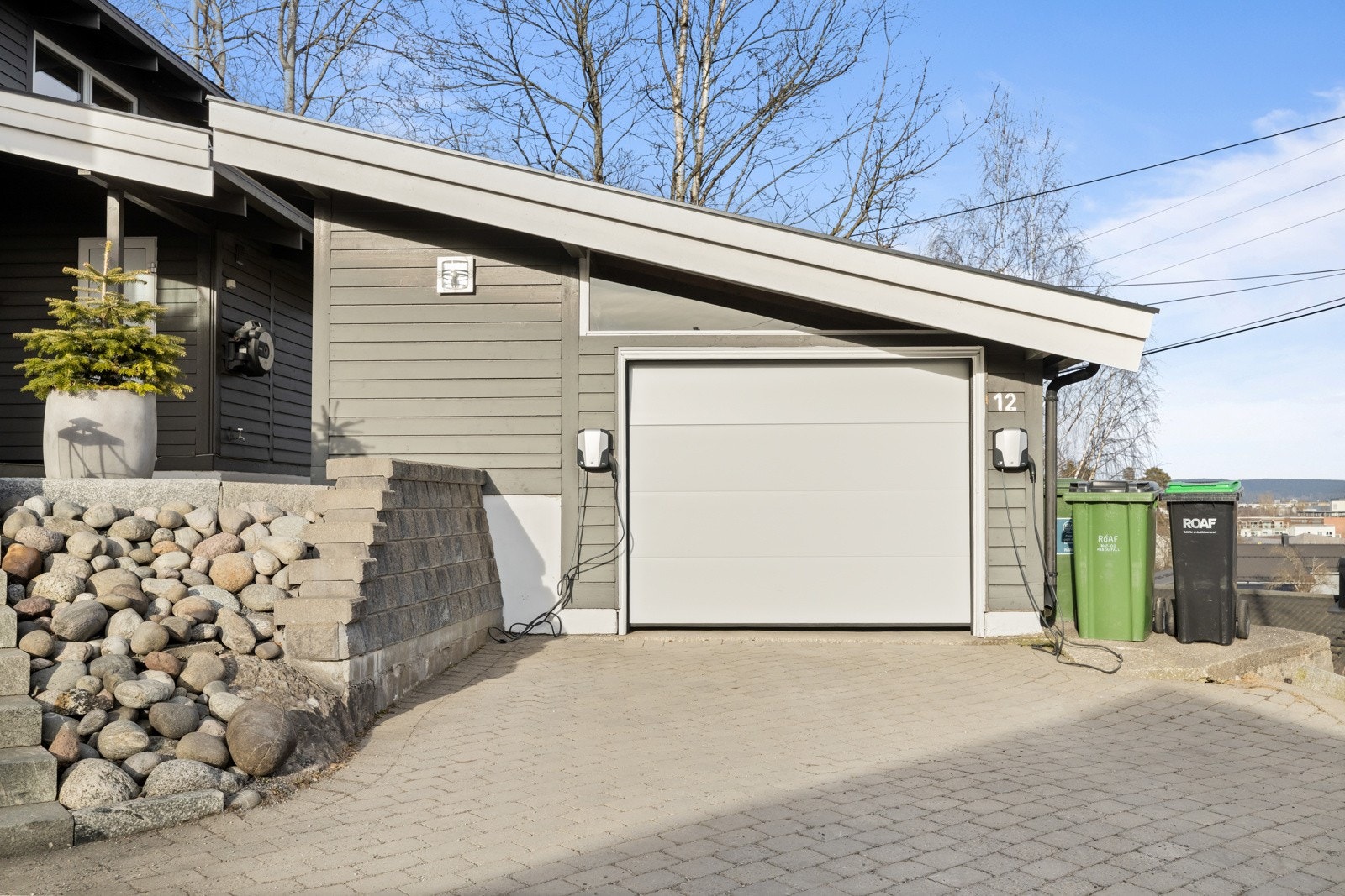 To el.bil-ladere er montert på garasjeveggen. Galleribilde