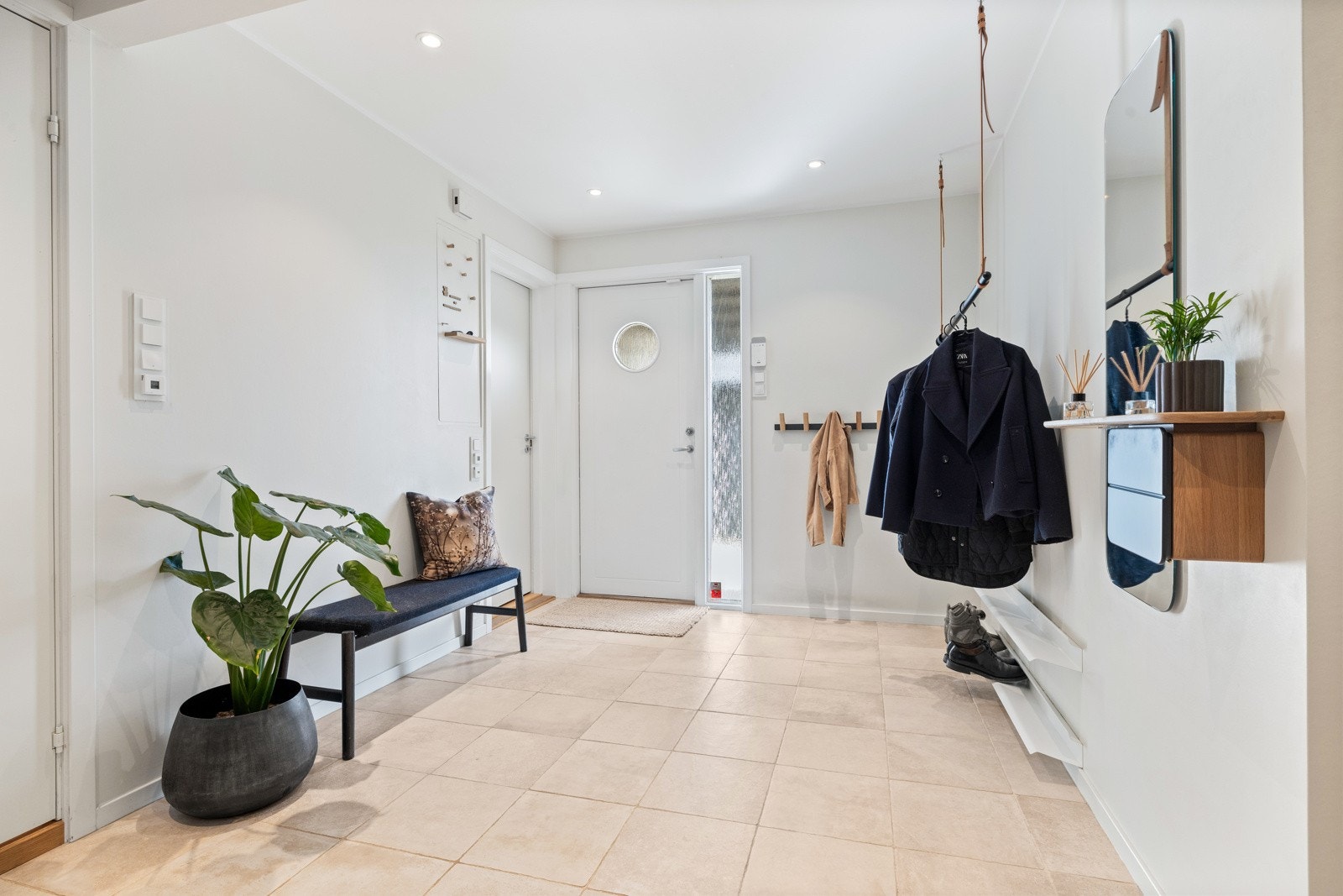 Romslig inngangsparti med flislagt gulv og god plass til klær og sko. Galleribilde