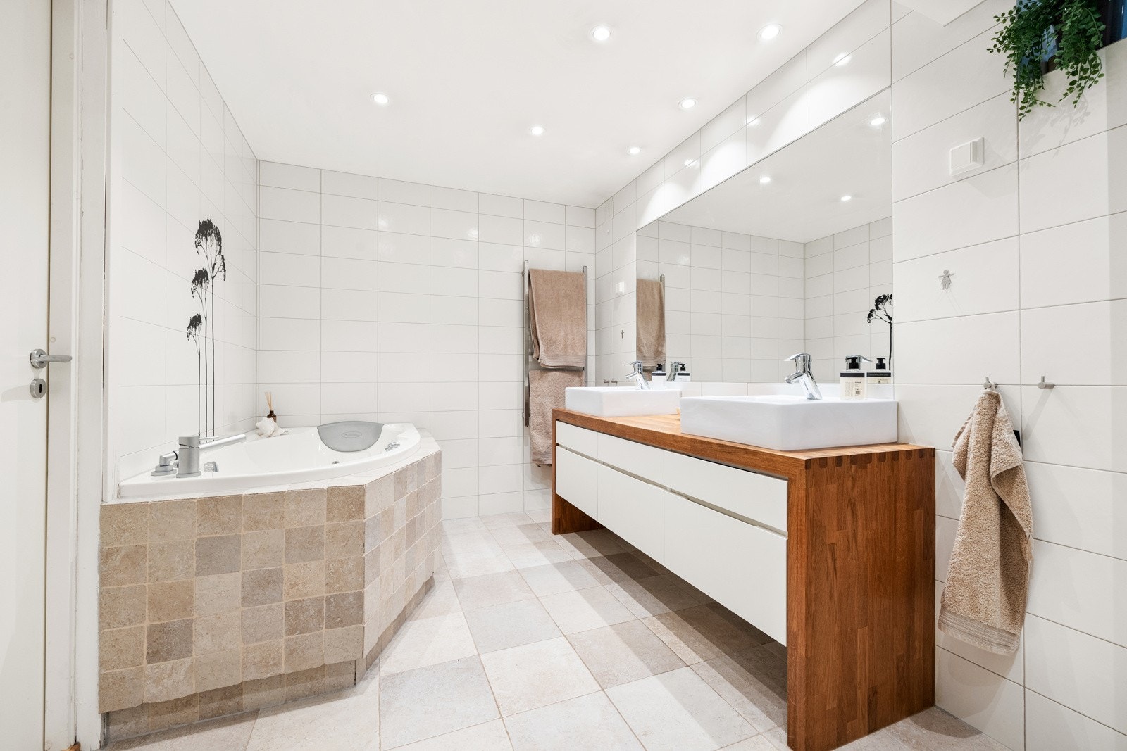 Komplett utstyrt med både regnfallsdusj med innfellbare dører og et innmurt boblebadekar for ekstra velvære. Galleribilde