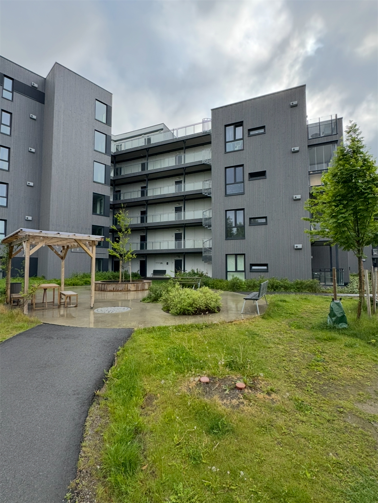 Trivelig inngangsparti med benker og beplantning Galleribilde