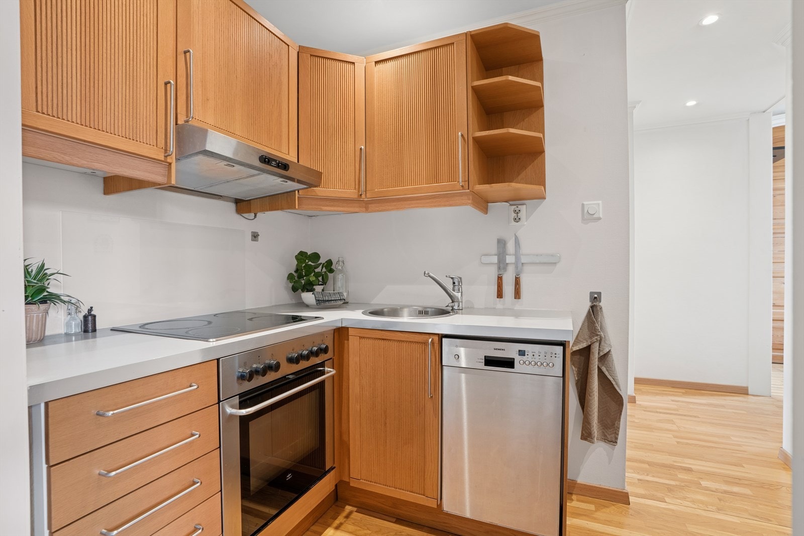 Kjøkken har godt med skap- og benkeplass. Det står et frittstående kjøleskap i motsatt hjørne av kjøkkenet. Galleribilde