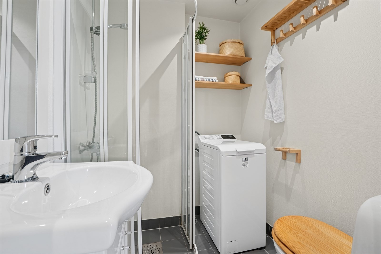 Lyst baderom med opplegg for vaskemaskin. Galleribilde