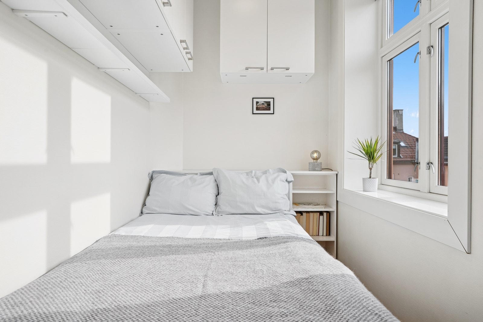 Lyst og delikat soverom med plass til seng og oppbevaring av klær. Galleribilde