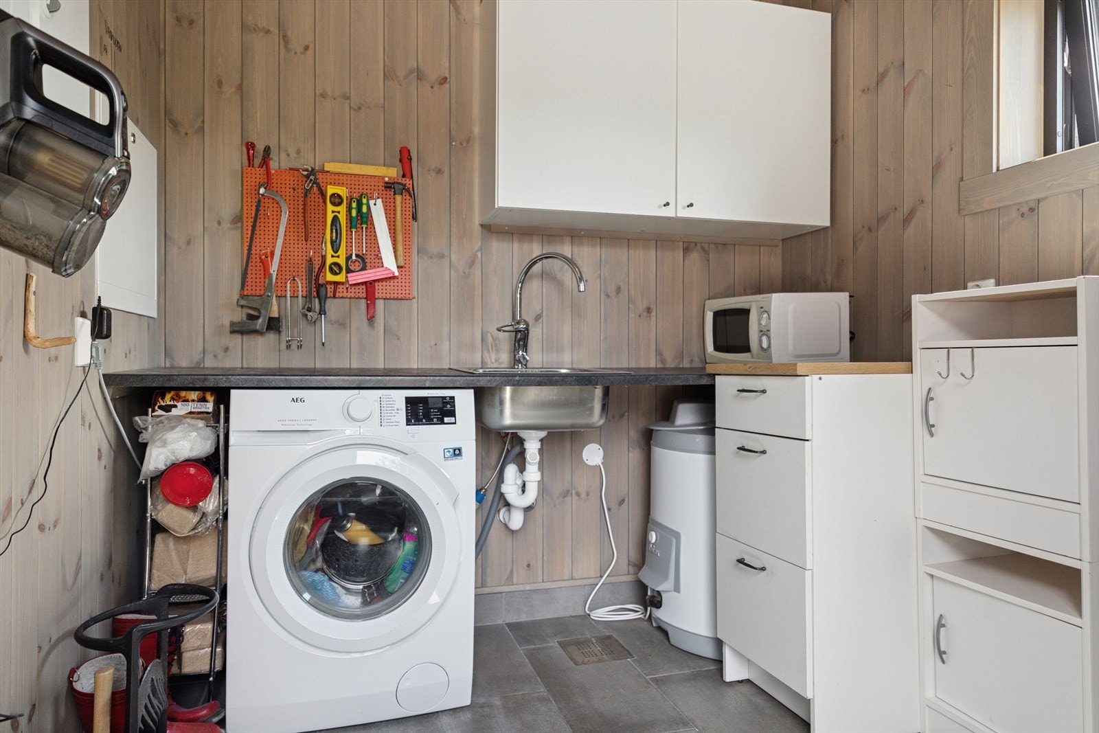 Dette er bod/teknisk/vaskerom med innredning for praktisk oppbevaring. Galleribilde