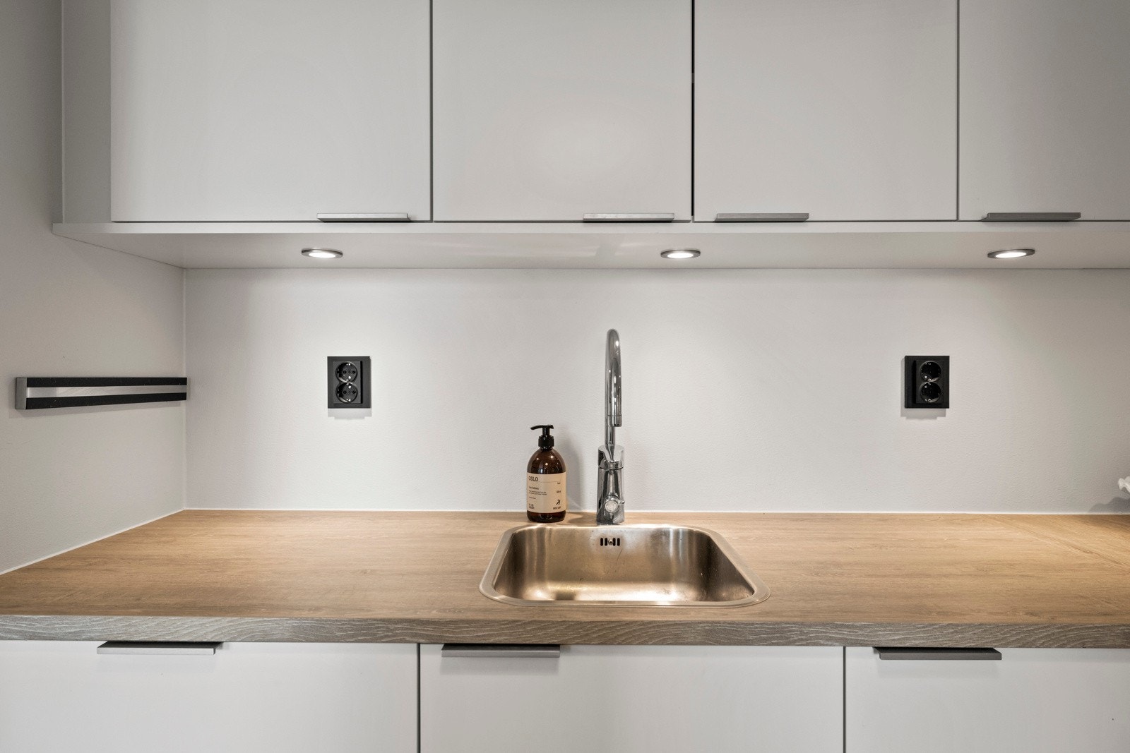 Den lyse laminatbenkeplaten gir en praktisk og slitesterk arbeidsflate Galleribilde