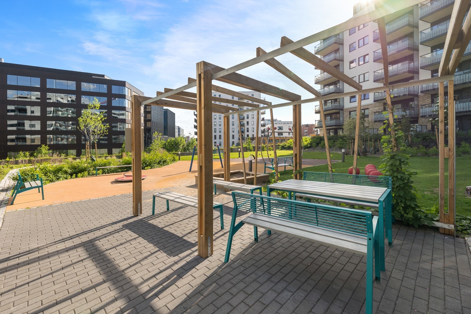 Felles uteområde med sittegrupper og pergola - en flott ramme for hyggelige måltider og møter med naboer i grønne og skjermede omgivelser. Galleribilde