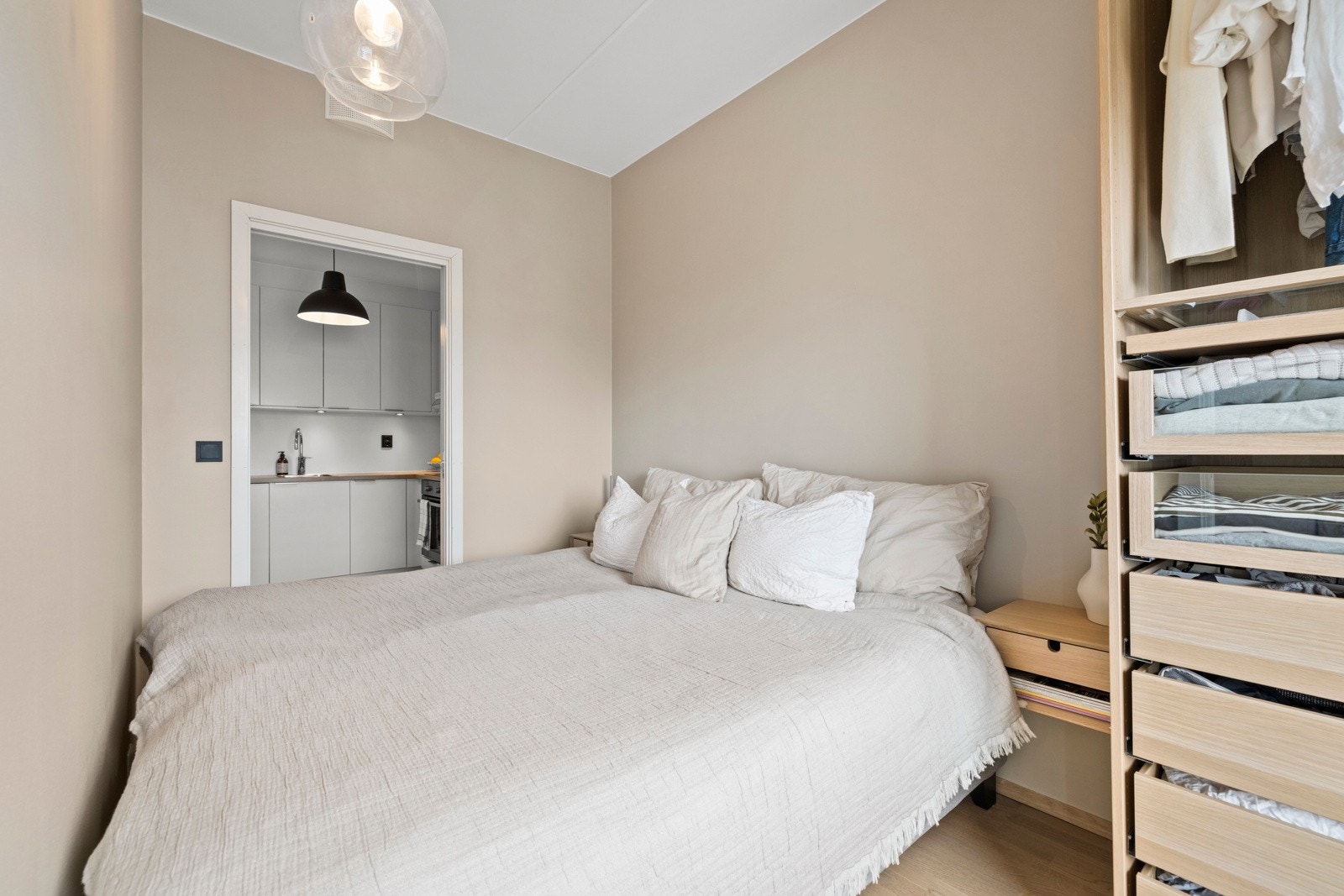 Rommet har plass til dobbeltseng og en åpen garderobeløsning med både skuffer og hyller. Galleribilde