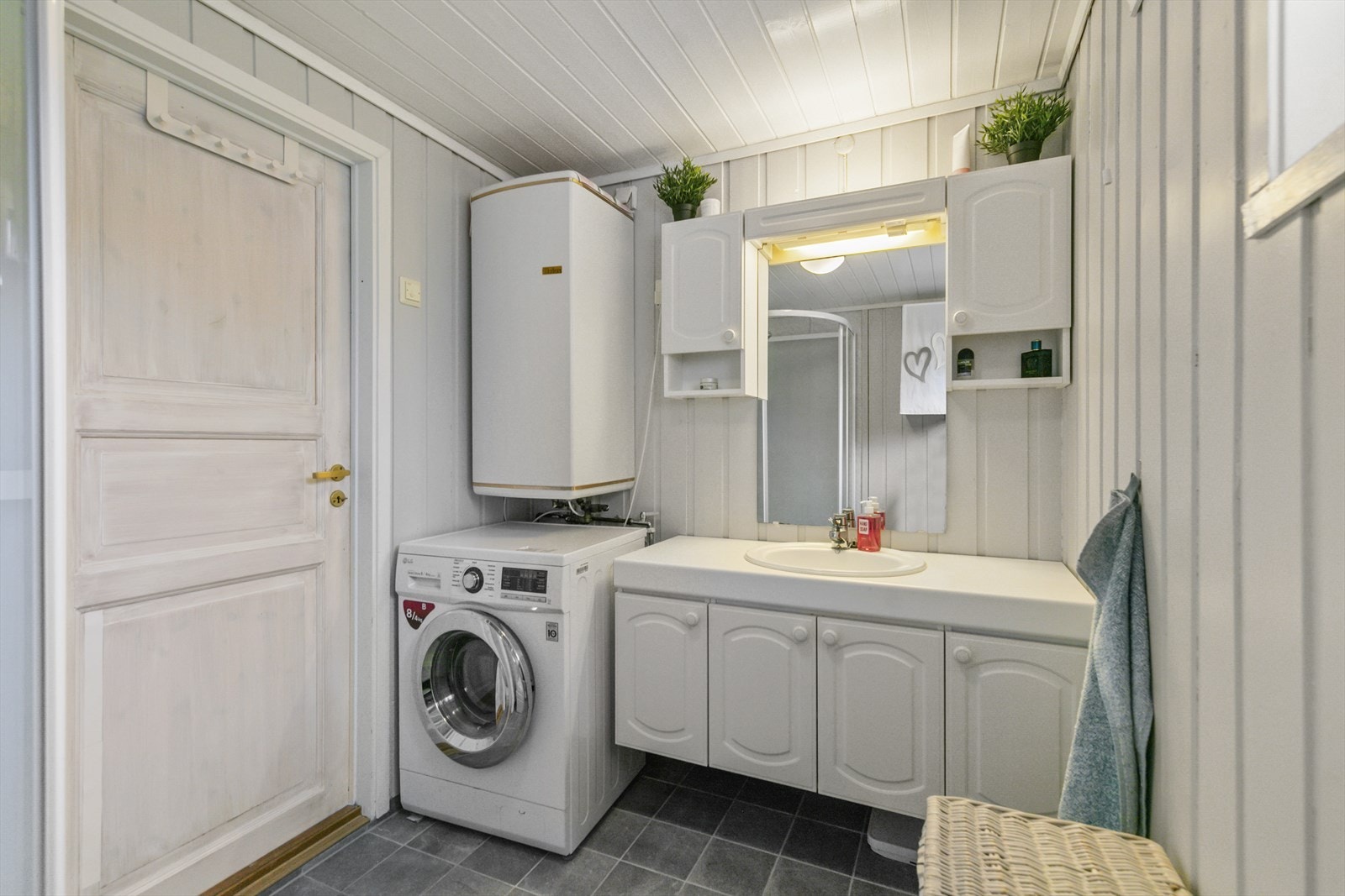 Badet inneholder opplegg for vaskemaskin, wc, servant i baderomsinnredning (byggeår) og dusjkabinett (2014). Galleribilde