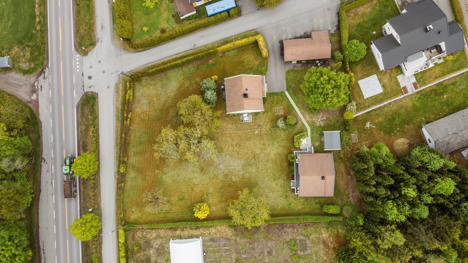 Tomten er pent opparbeidet med gressplen på store deler, div. beplantning og asfaltert gårdsplass. Galleribilde