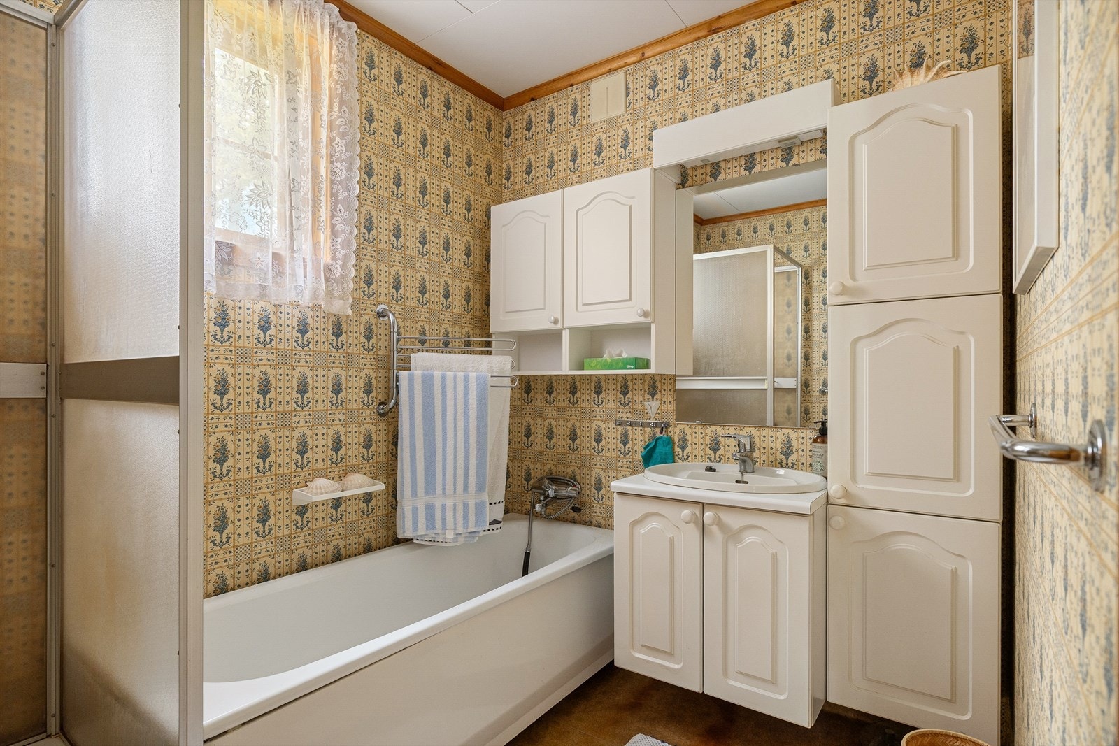 Baderom med hvit innredning med nedfelt vask, badekar og dusjkabinett. Galleribilde