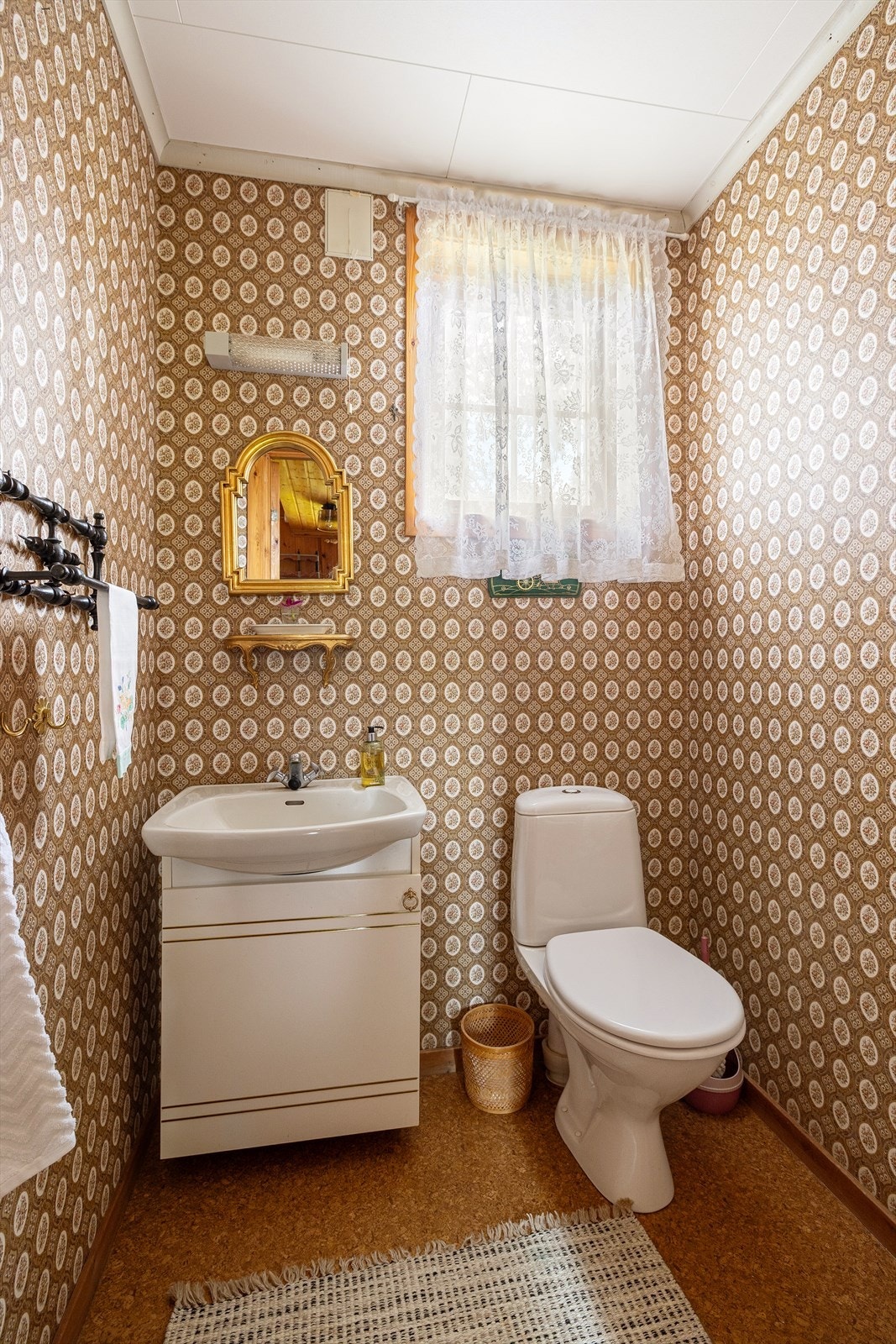 Toalettrom med hvit innredning med nedfelt vask og gulvmontert toalett. Galleribilde