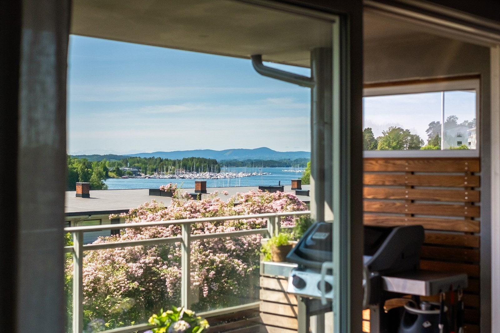Gjennom de store vindusflatene i stuen har man et nydelig utsyn utover nærområdet og på balkongen kan man nyte late dager med fantastisk utsikt over fjorden! Galleribilde