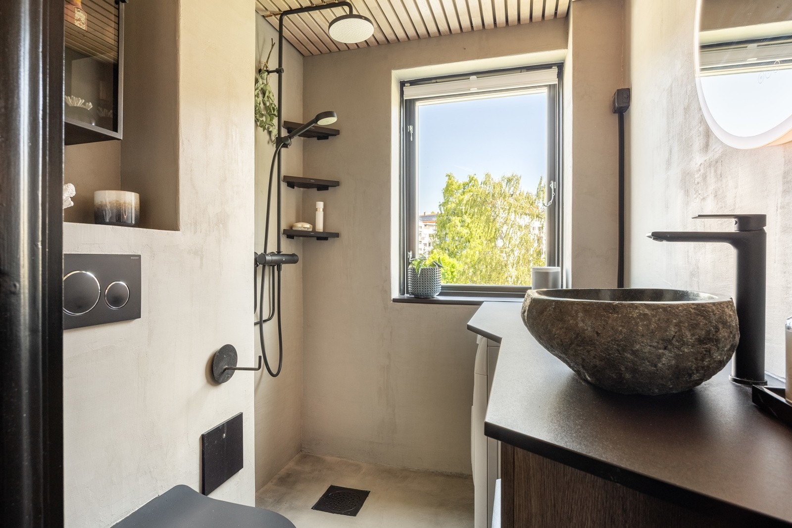 Badet fremstår delikat med en moderne utførelse. Rommet har mikrosement på gulv og vegger, samt spiler i lys eik montert i tak. Galleribilde