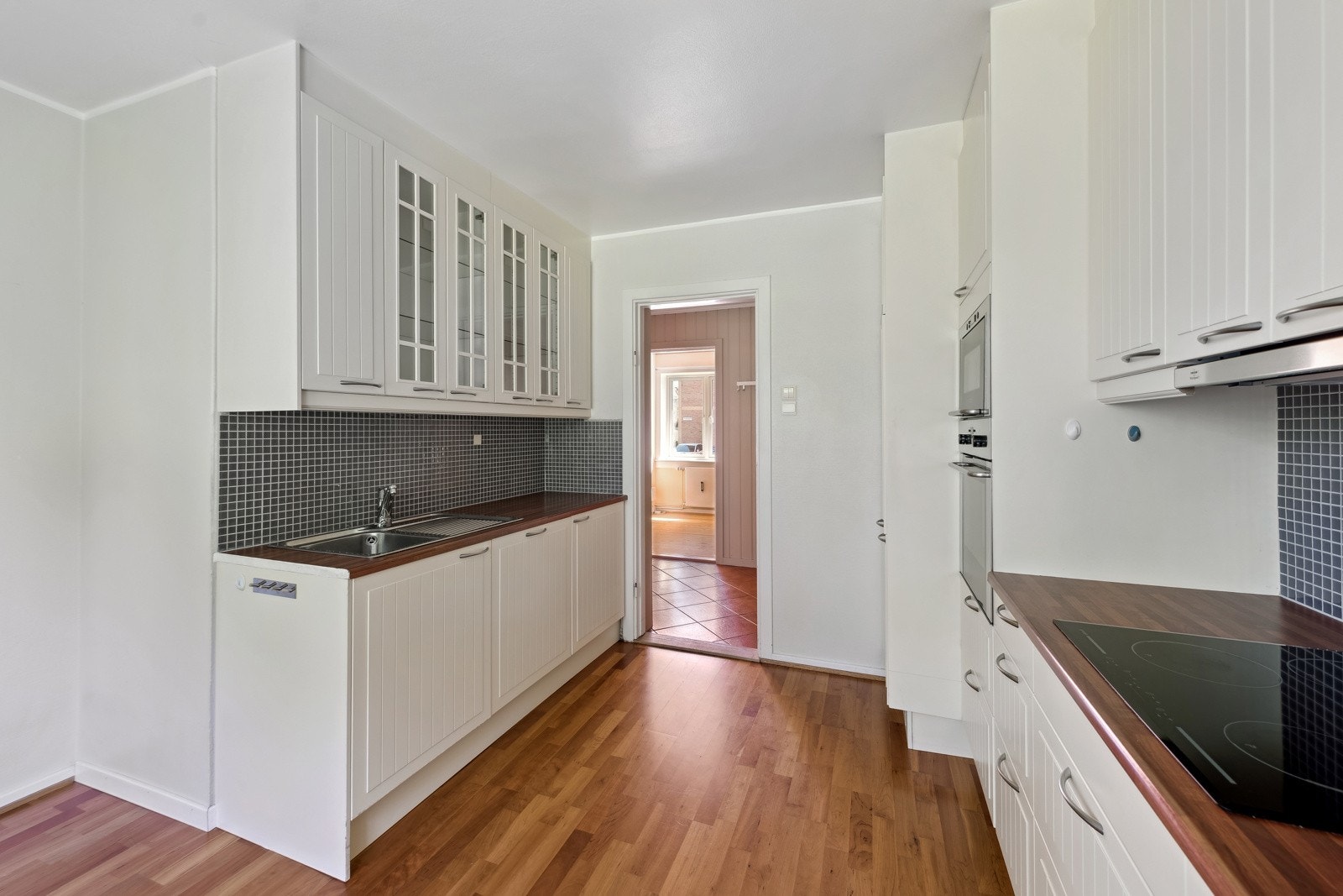 Kjøkkeninnredning med profilierte fronter og benkeplate i laminat. Nedfelt oppvaskkum med ettgreps blandebatteri. Galleribilde